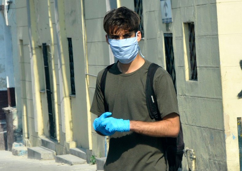 Joven usando guantes y nasobuco. Autor: Abel Rojas Barallobre