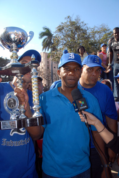 Germán Mesa, director del equipo Industriales, exhibe el trofeo que los acredita como campeones
