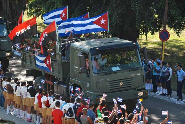 Multitud de pioneritos sobre camiones