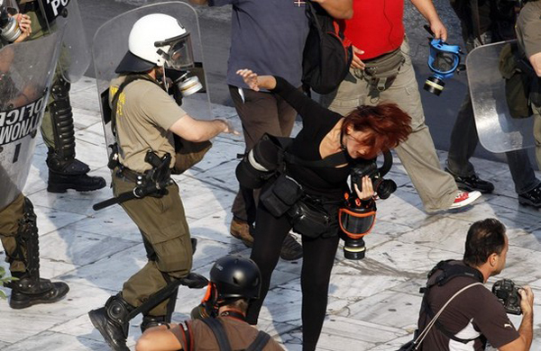 Agente de seguridad golpea a una fotorreportera griega