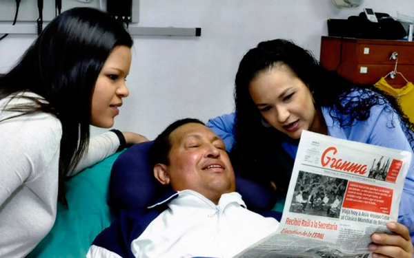 Chávez lee el diario Granma junto a sus hijas