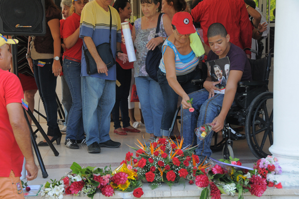 Niño cubano ofrece flores a Chávez