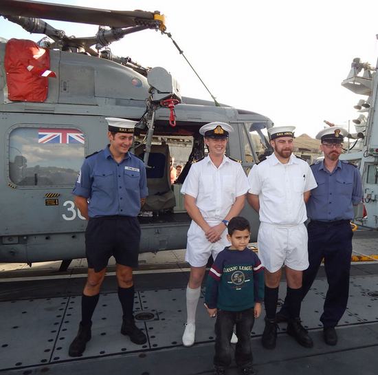 Miembros de la Marina Real junto a un niño