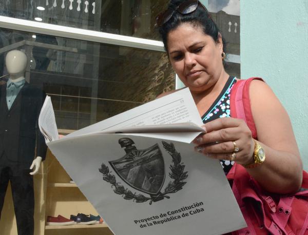Mujer cubana leyendo el Proyecto de Constitución