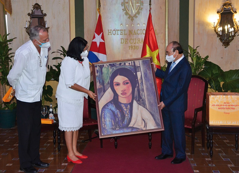 Noemí Rabasa le entrega al presidente un cuadro con nuestra Gitana tropical.