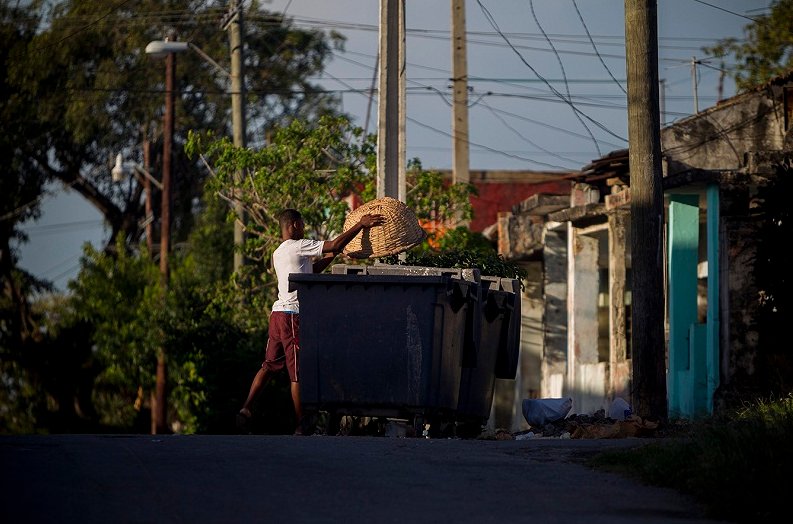 Hombre echando basura en un latón