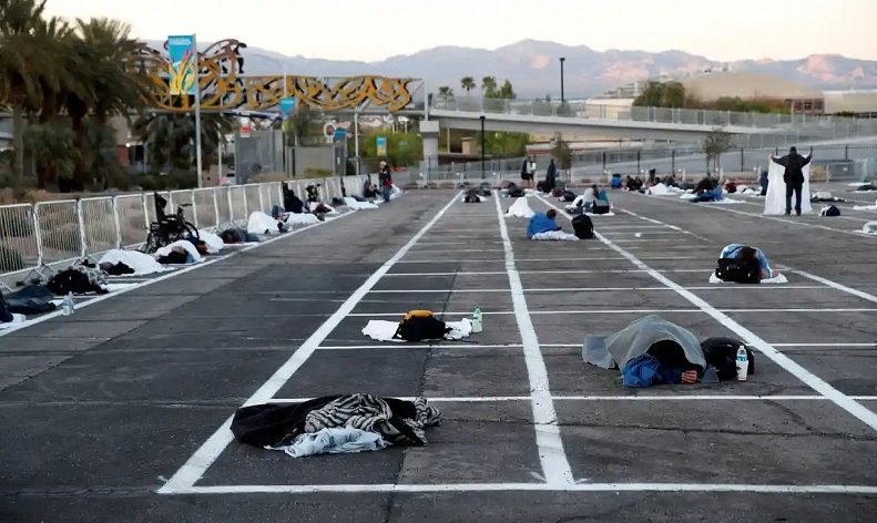 Personas sin casa duermen en el lote con los espacios marcados para guardar distancias en Las Vegas