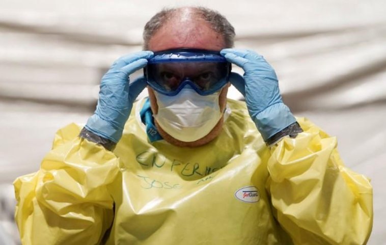Un trabajador sanitario se prepara para la llegada de pacientes con coronavirus en un gigante hospital militar instalado en recinto ferial de IFEMA en Madrid