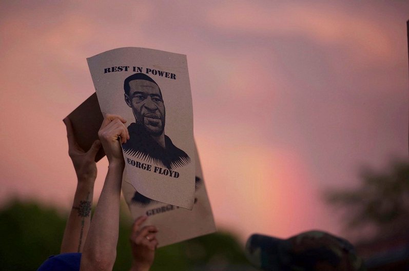 Manifestantes muestran un cartel con la imagen de George Floyd