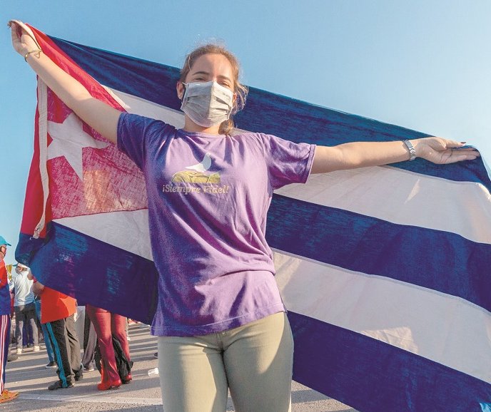 Joven alzando la bandera cubana.