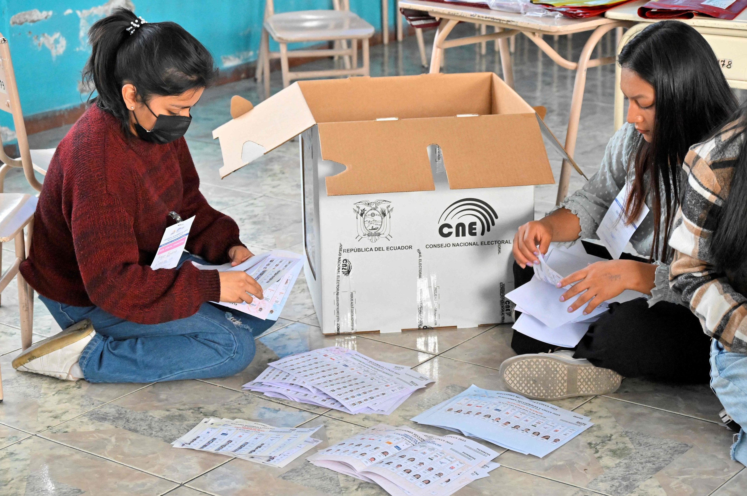 Dos miembros de una mesa electoral en Quito  cuentan los votos