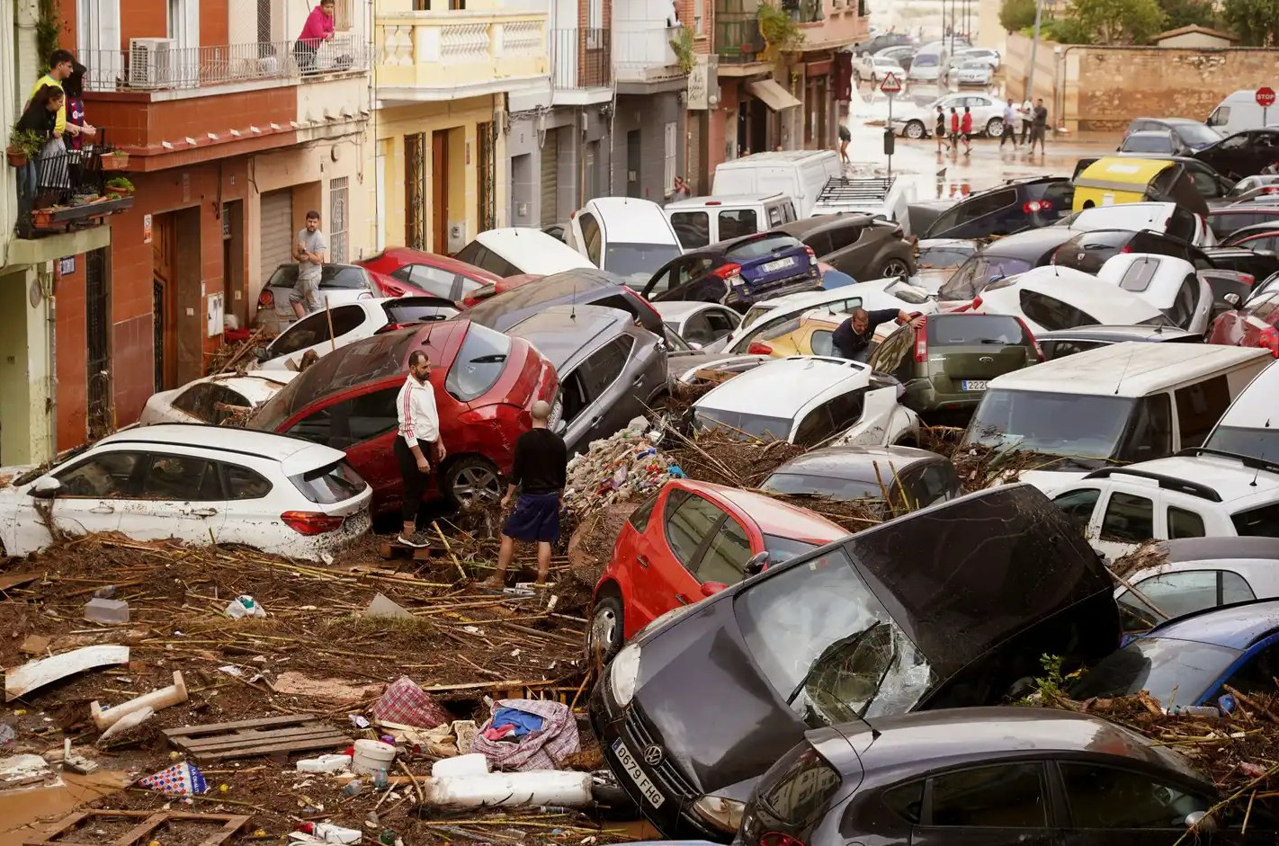 Vehículos apilados en el barro después de ser arrastrados por las inundaciones en Valencia, España
