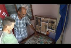 Arnaldo Cruz Ricardo, junto a su nieto, muestra la urna que contiene las historias de la Zona Cederista.