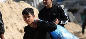 Un niño lleva sus pertenencias mientras su familia abandona su hogar en el campo de refugiados de Nur Shams, en el norte de Cisjordania.