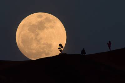 Las siluetas con la superluna de fondo mágico.