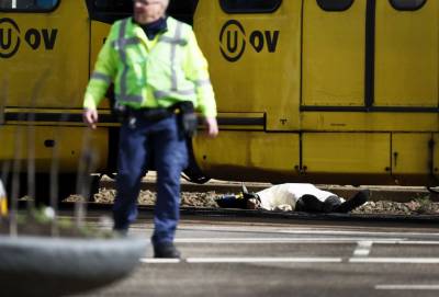 Un agente frente a un cuerpo cubierto con una manta en la zona del tiroteo en ciudad holandesa
