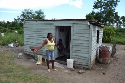 Mujer al frente de una casa de madera