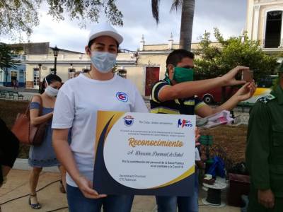 La directora provincial de Salud, Ailuj Casanova Barreto, recibe un reconocimiento a nombre de todos los trabajadores del sector.