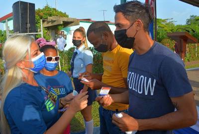 Lissette González, primera secretaria de la UJC, entrega el carné a los nuevos militantes en Isla de la Juventud