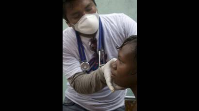 Integrante del contingente médico internacional Henry Reeve examina a una mujer