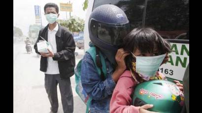 Habitantes se protegen de cenizas de volcán.