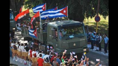 Multitud de pioneritos sobre camiones