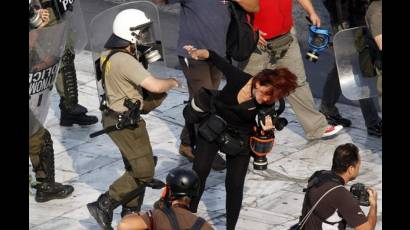 Agente de seguridad golpea a una fotorreportera griega