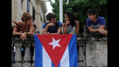 Jóvenes cubanos junto a la enseña nacional 
