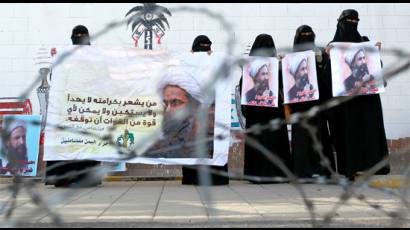 Mujeres yemenitas enarbolan retratos del prominente clérigo chiíta Nimr al-Nimr ante la Embajada saudita en Sanaa.
