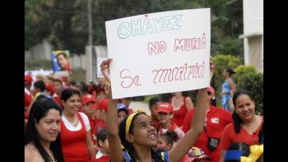Niña levanta una pancarta en homenaje al Comandante Hugo Chávez