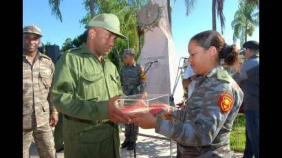 El capitán de corbeta Bernardo Guído Perdomo entrega el documento a la primer teniente Yaisis Isaac, oficial de organización de la UJC en la Brigada de la Frontera