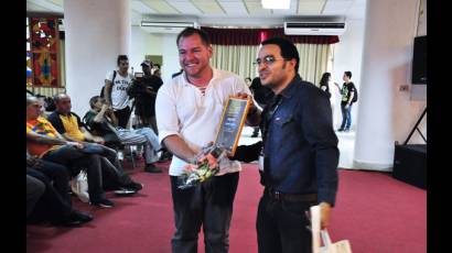 Rubiel García, presidente de la AHS (derecha), entregó a Maikel Rodríguez el reconocimiento que lo acredita como el ganador en literatura infantil por La isla iluminada