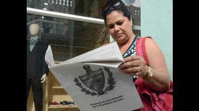 Mujer cubana leyendo el Proyecto de Constitución