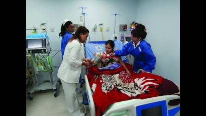 Paciente venezolana; al fondo, enfermera local; a los lados, enfermera y doctora cubana. La obra se llama Solidaridad.