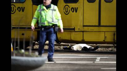 Un agente frente a un cuerpo cubierto con una manta en la zona del tiroteo en ciudad holandesa