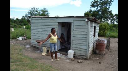 Mujer al frente de una casa de madera