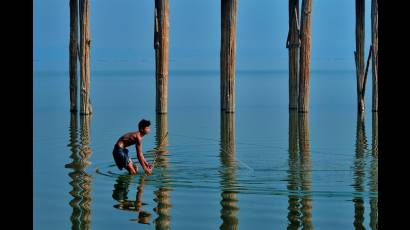 Niño pescando en el lago Taungthaman