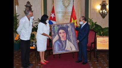 Noemí Rabasa le entrega al presidente un cuadro con nuestra Gitana tropical.