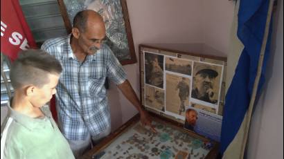 Arnaldo Cruz Ricardo, junto a su nieto, muestra la urna que contiene las historias de la Zona Cederista.