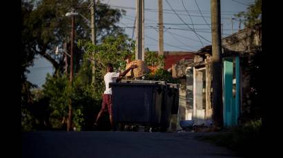 Hombre echando basura en un latón