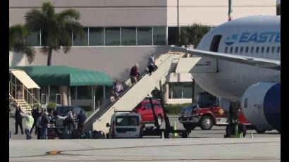 Trabajadores medicos guian a un paciente del crucero Zaandam hacia una ambulancia que espera en Fort Lauderdale