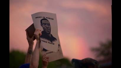 Manifestantes muestran un cartel con la imagen de George Floyd