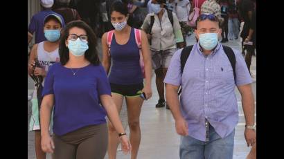 Personas caminan por la calle usando nasobuco