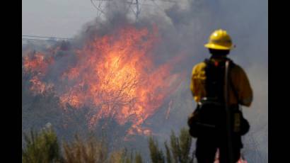 Un bombero monitorea las llamas en Santa Clarita, California
