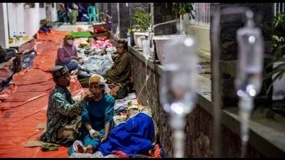 Lesionados siendo atendidos en las afueras de un hospital de campaña.