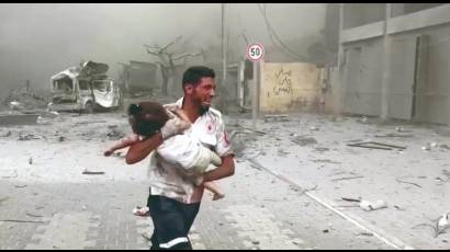 Un médico corre con un niño herido en el bombardeo a Gaza