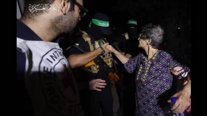 Una de las israelíes liberadas da la mano a uno de los combatientes de Hamás.