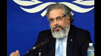  Rodolfo Benítez Verson, embajador y representante permanente de Cuba ante la ONU, denunció hoy en la Conferencia de Desarme en Ginebra, Suiza, la amenaza de una agresión militar directa contra la isla por parte de Estados Unidos, informó la Misión de Cuba en Ginebra desde su perfil en la red social Facebook.     El diplomático afirmó que un ataque violaría la Carta de la ONU y el Derecho Internacional, y provocaría graves pérdidas humanas tanto en Cuba como en Estados Unidos.     Benítez señaló que el gobierno estadounidense recrudeció el bloqueo económico, comercial y financiero con sanciones adicionales y un cerco energético que desde el 29 de enero impide la entrada de combustible, equivalente a un bloqueo naval.     Explicó que las medidas han generado cortes de electricidad, dificultades en el suministro de agua y gas, afectaciones en la producción de alimentos y servicios médicos, así como un aumento de la mortalidad infantil y la reducción de la expectativa de vida en niños enfermos de cáncer.     El embajador calificó de arbitraria la instrucción de cargos penales contra el líder de la Revolución Cubana, General de Ejército Raúl Castro Ruz, y la consideró un intento de justificar una acción militar.     Reiteró la disposición de Cuba a mantener conversaciones bilaterales sin injerencia en sus asuntos internos, y llamó a la comunidad internacional a impedir una agresión que tendría consecuencias impredecibles.     Benítez pidió solidaridad con Cuba frente al bloqueo de combustible y las amenazas militares, y aseguró que el pueblo cubano defenderá su soberanía e independencia hasta las últimas consecuencias.
