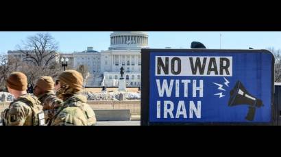 Guardias Nacionales pasan junto a un camión que llama a No Guerra Con Irán