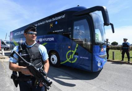 Un policía monta guardia junto al autobús de la selección de fútbol suiza